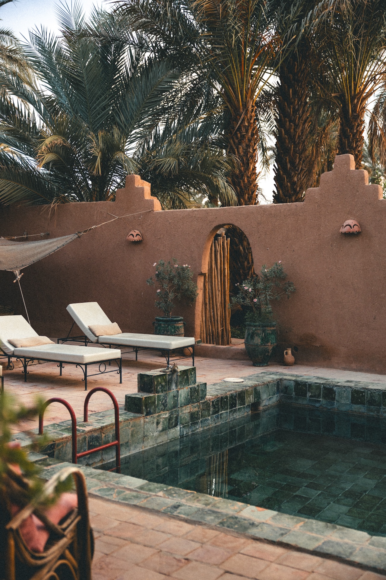 Poolside lounge area with sunbeds and traditional Moroccan architecture at Dar Sofar, Agdz