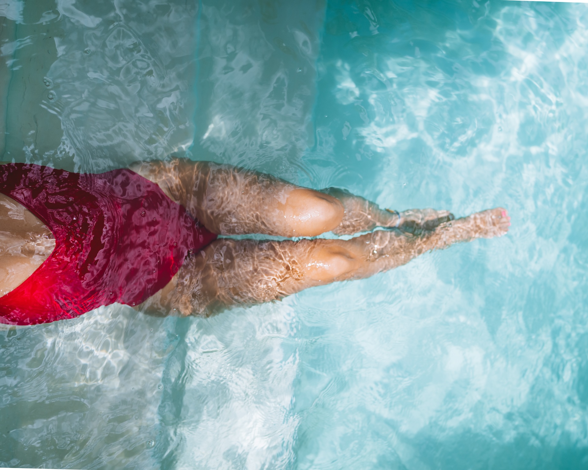 Person swimming in the clear blue pool at Hacienda San Antonio Millet