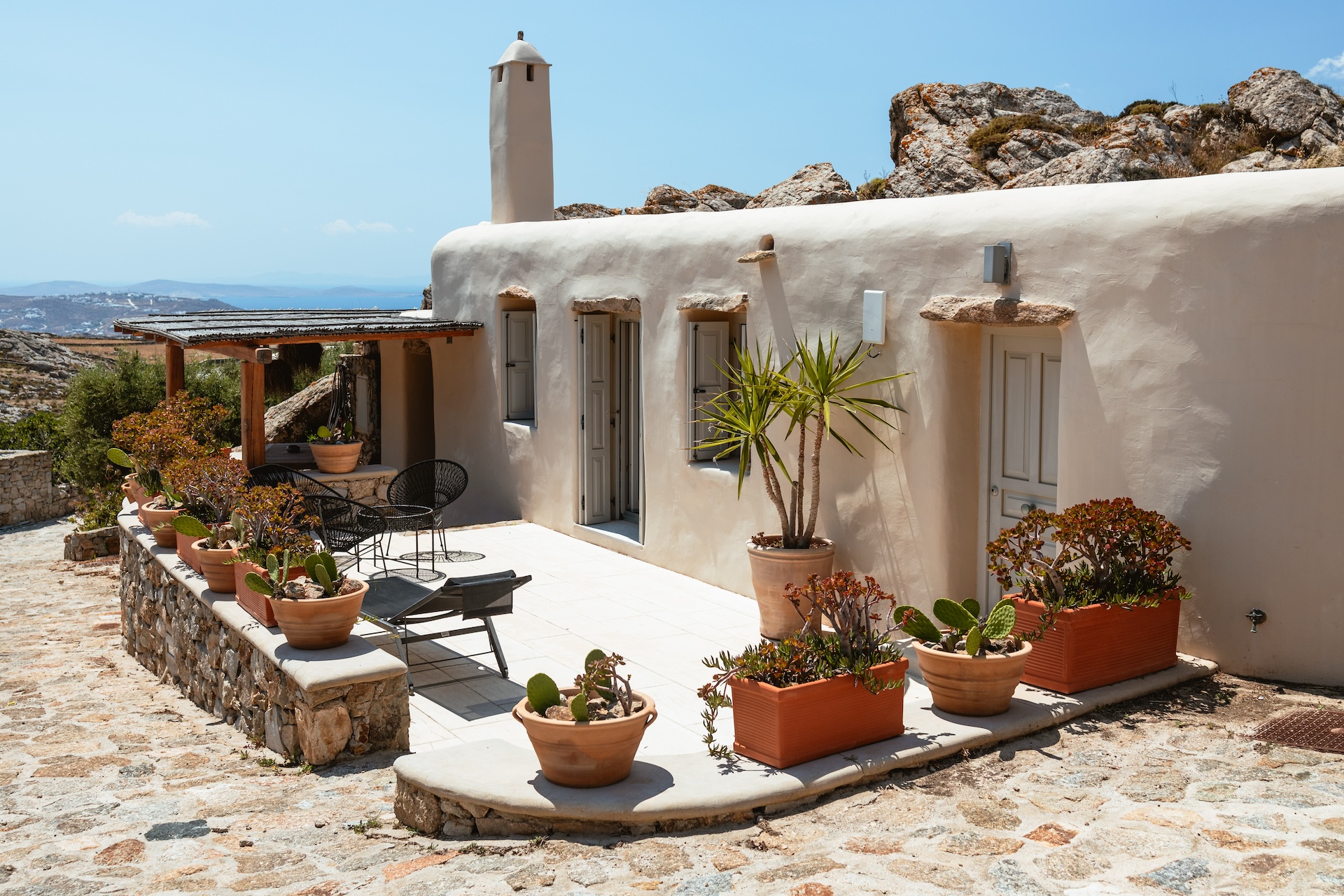 Sunny summer terrace with potted plants at a private villa in Mykonos, Greece