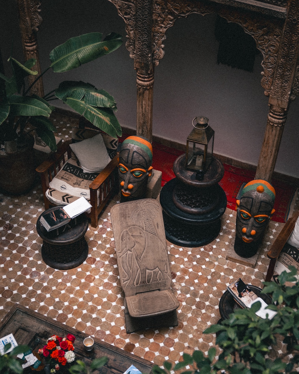 Traditional Moroccan courtyard with African masks and carved wooden decor at Riad Kafila, Essaouira