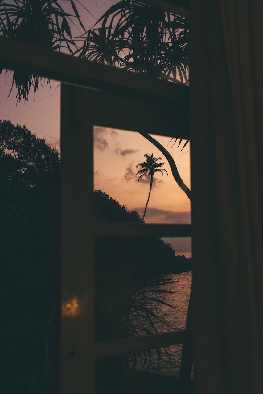 Reflective sunset view through a window at Soul & Surf Sri Lanka near Ahangama Beach