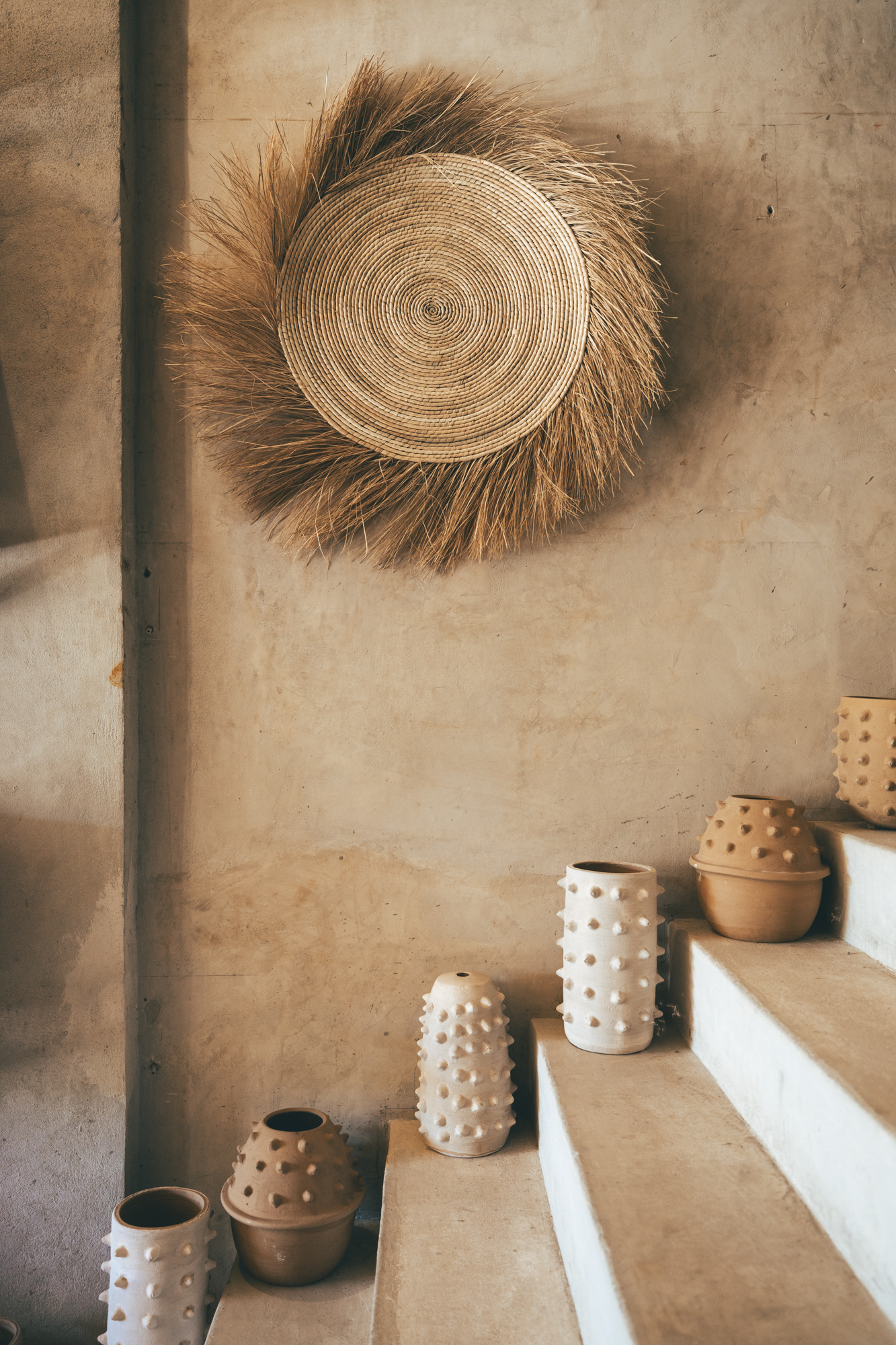 Traditional straw wall art and pottery on display at a craft shop in Tulum