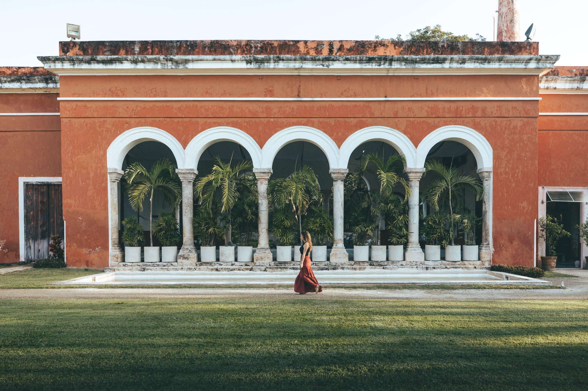 Stylishly placed hat and swimwear in the sun-dappled courtyard of Hacienda San Antonio Millet, reflecting sophisticated interior design