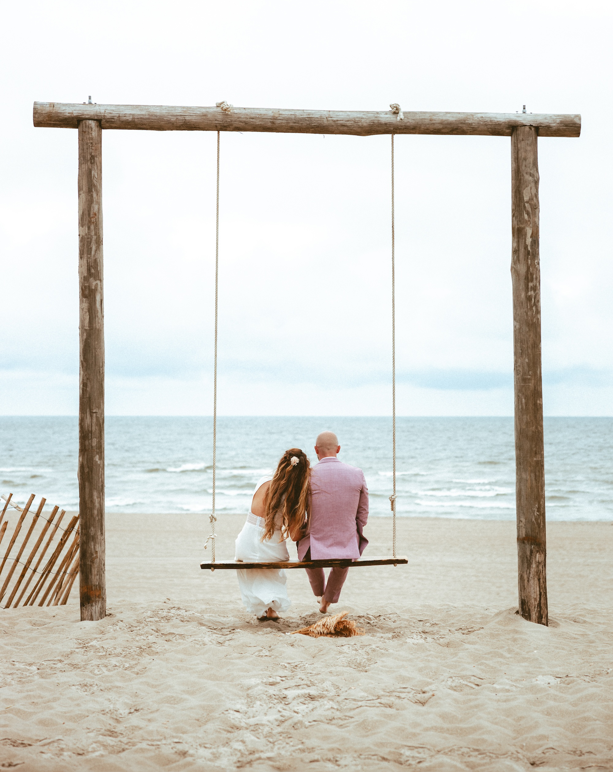 Couple sitting on a swing at the beach