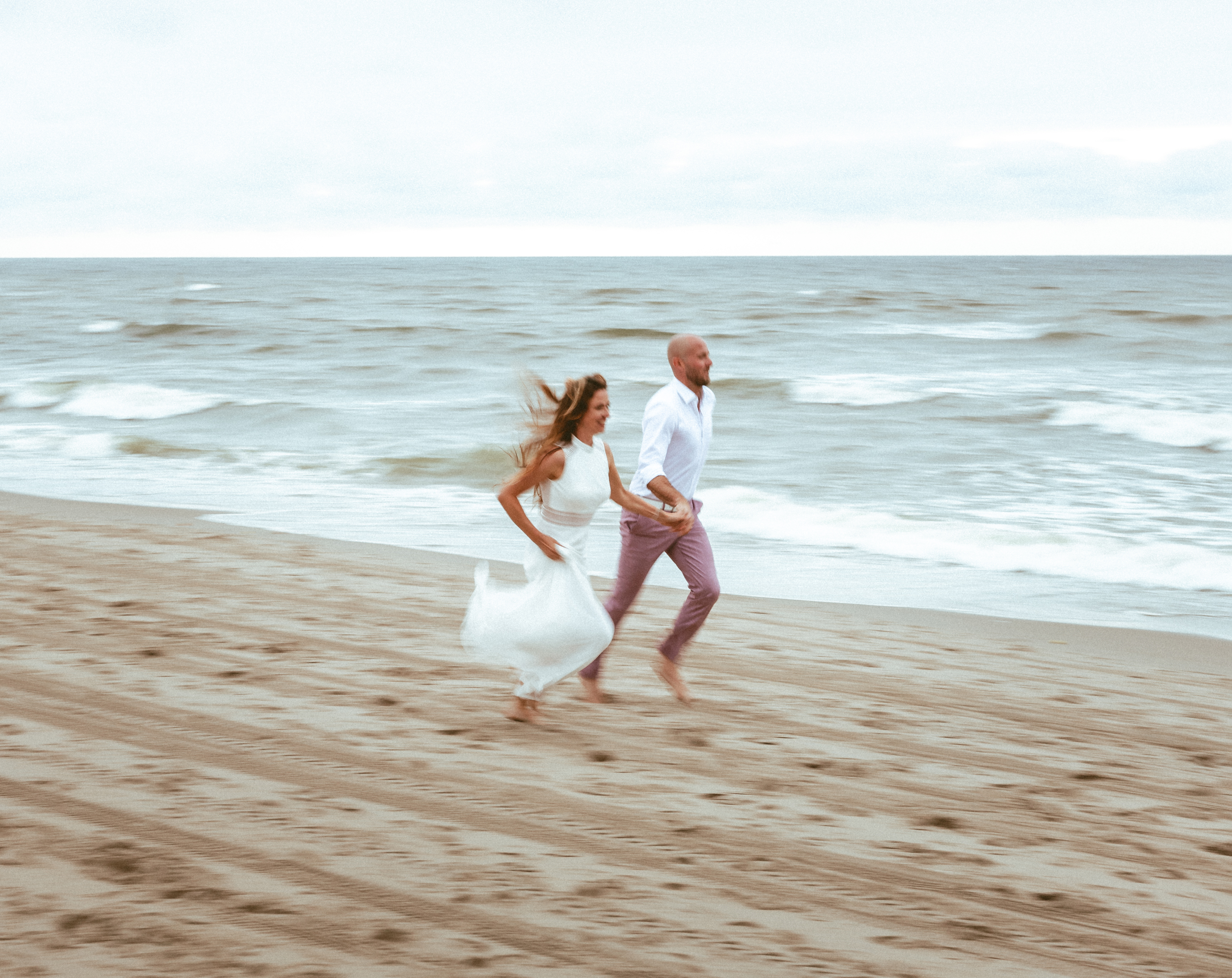 Couple running together along the shoreline