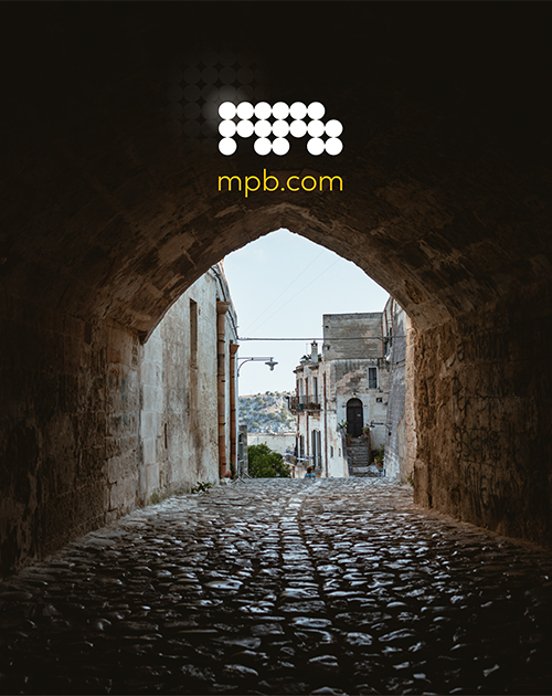 A captivating stone archway framing a historic city, the kind of iconic photography that can be captured with high-quality gear from MPB