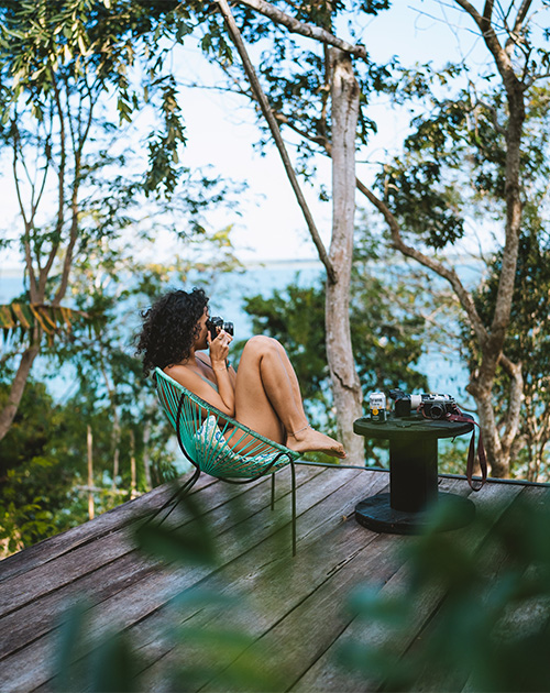 Woman photographer in vibrant attire capturing the essence of jungle retreat in Bacalar