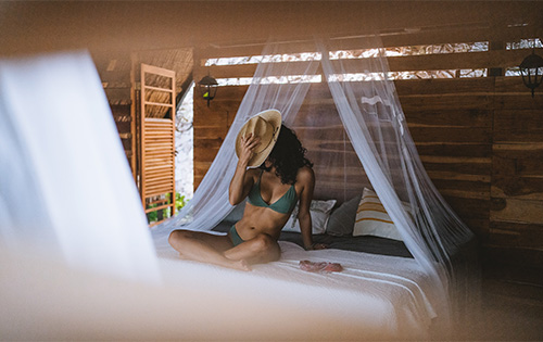 Tranquil moment of a woman in a serene pose amidst the natural setting of an eco-retreat cabin