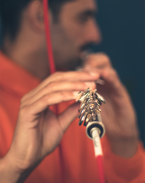 Close-up of Dillon's hands playing a flute with precision, a testament to his musical versatility