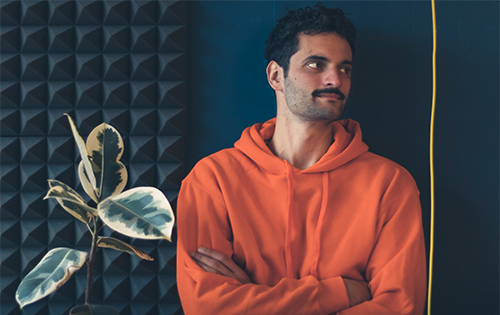 Dillon in a contemplative moment, surrounded by acoustic foam, symbolizing the blend of tradition and technology in music