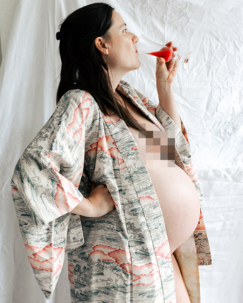 Pregnant woman in a floral robe, enjoying a moment of tranquility with fruit