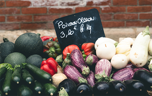 Colorful display of fresh vegetables with a chalkboard price sign at a local market