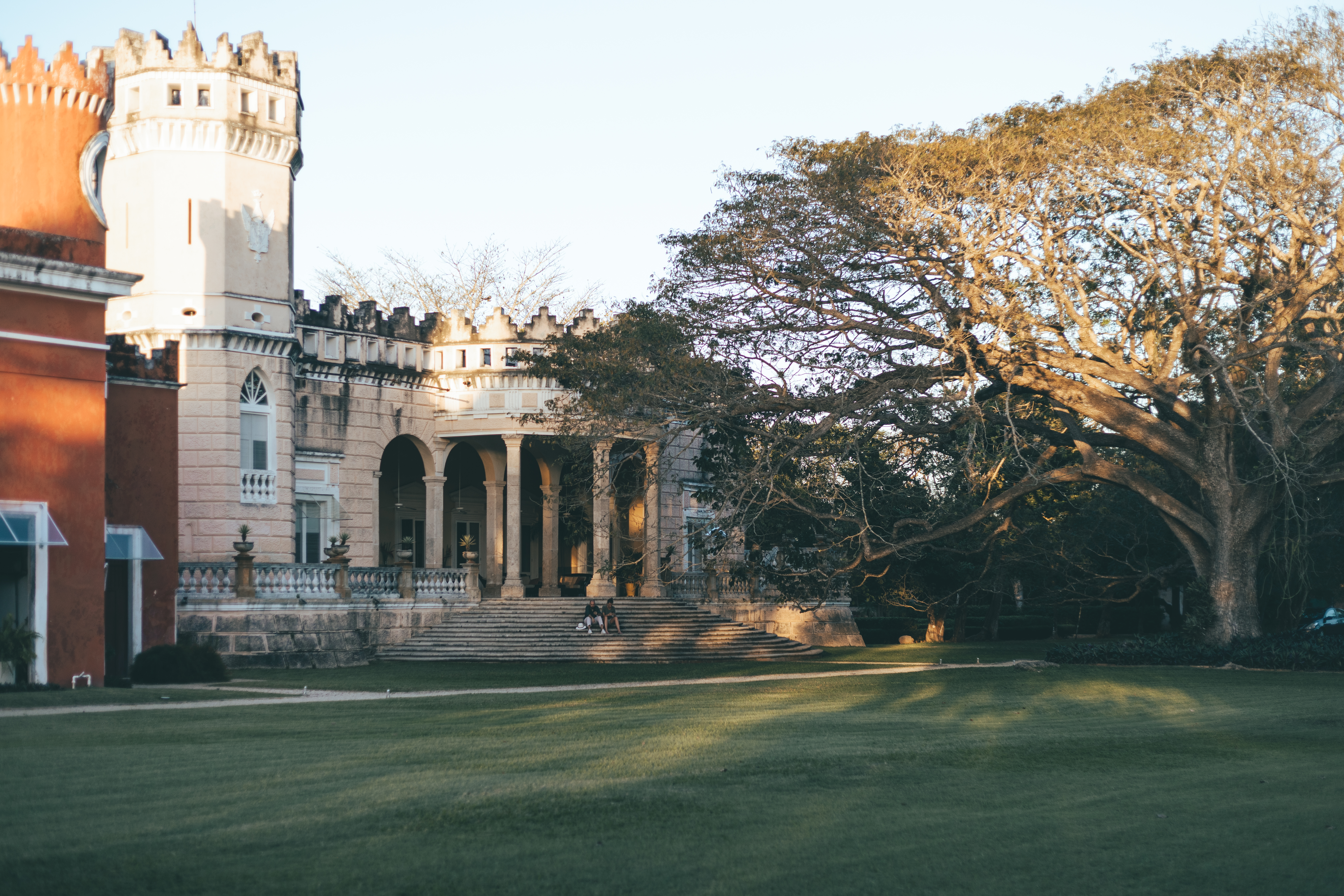 Golden sunset light bathing the facade of Hacienda San Antonio Millet with its lush greenery