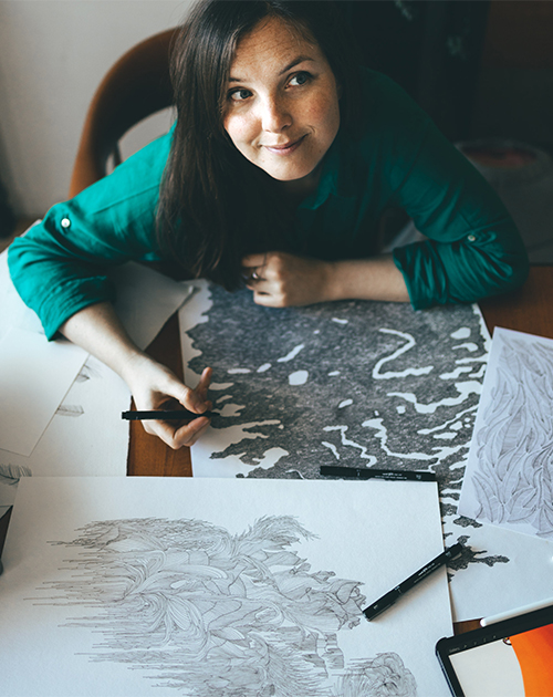 Graphic artist Visnja looking inspired while hand-drawing a piece, showcasing her artistry in Rotterdam studio