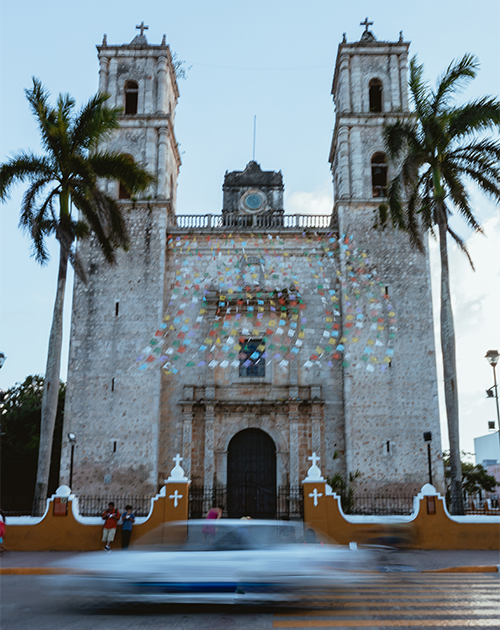 Historic colonial church in Yucatan adorned with colorful festive decorations, capturing the cultural spirit of Mexico