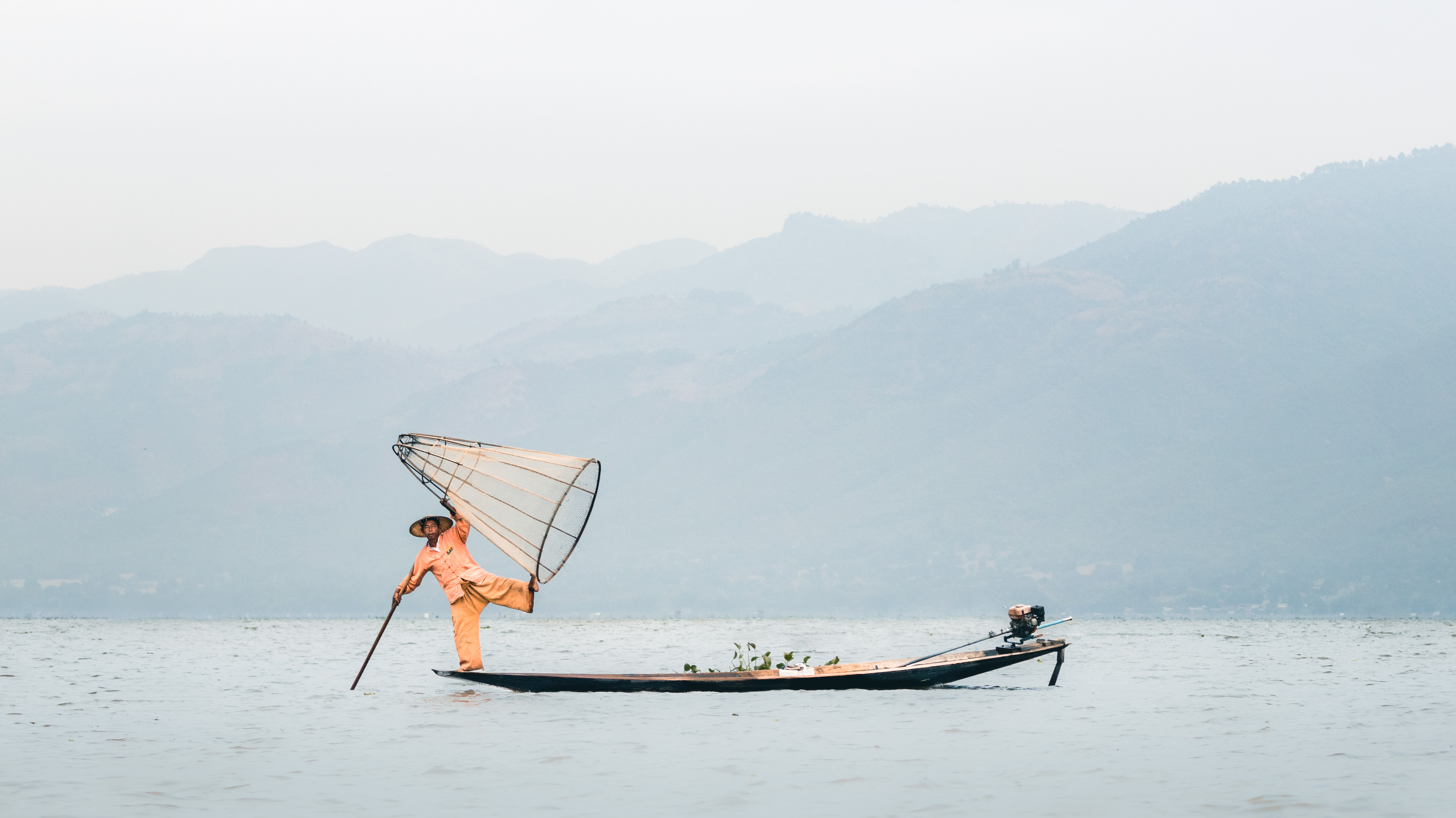 Traditional fisherman skillfully navigating the tranquil waters of Lake Inle in Myanmar